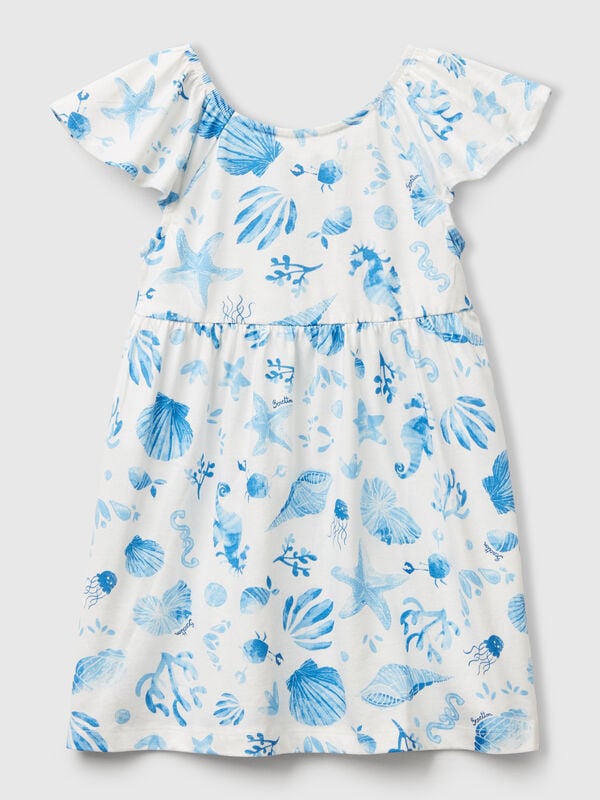 Vestido blanco con conchas azules. Niña