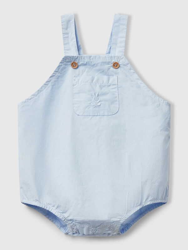 Peto de puro algodón. Tirantes ajustables con botones efecto madera, bolsillo de parche en la parte delantera y elástico interno en la pierna. Apertura con botones a presión en la entrepierna. Perfecto con una camiseta colorida. Recién nacidos