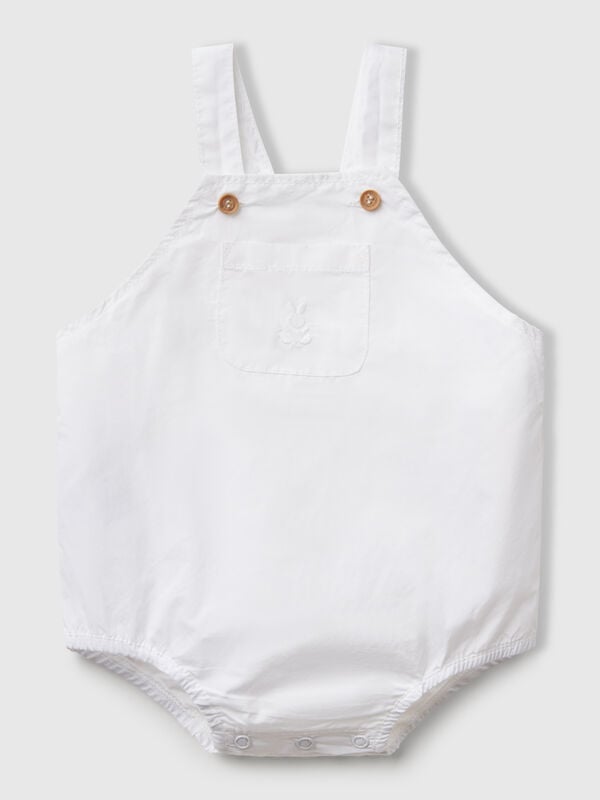 Peto de puro algodón. Tirantes ajustables con botones efecto madera, bolsillo de parche en la parte delantera y elástico interno en la pierna. Apertura con botones a presión en la entrepierna. Perfecto con una camiseta colorida. Recién nacidos