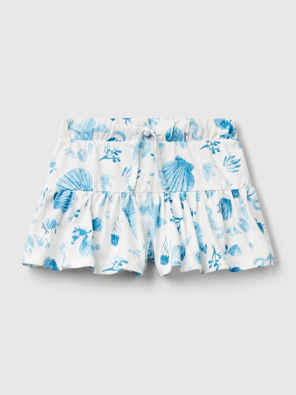 Pantalón corto blanco con conchas azules. Niña