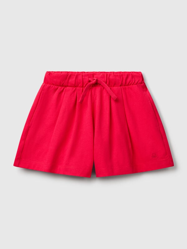 Pantalón corto de puro algodón de tacto cálido. Cintura con cordón, bolsillos insertados en los laterales y logo bordado en el bajo izquierdo. Perfecto para outfits cotidianos. Niña