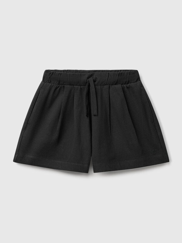 Pantalón corto de puro algodón de tacto cálido. Cintura con cordón, bolsillos insertados en los laterales y logo bordado en el bajo izquierdo. Perfecto para outfits cotidianos. Niña