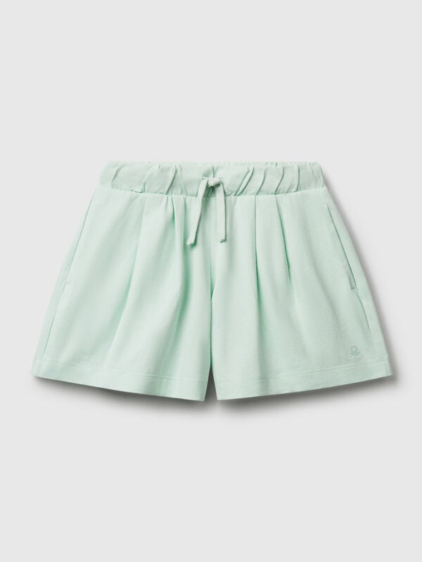 Pantalón corto de puro algodón de tacto cálido. Cintura con cordón, bolsillos insertados en los laterales y logo bordado en el bajo izquierdo. Perfecto para outfits cotidianos. Niña