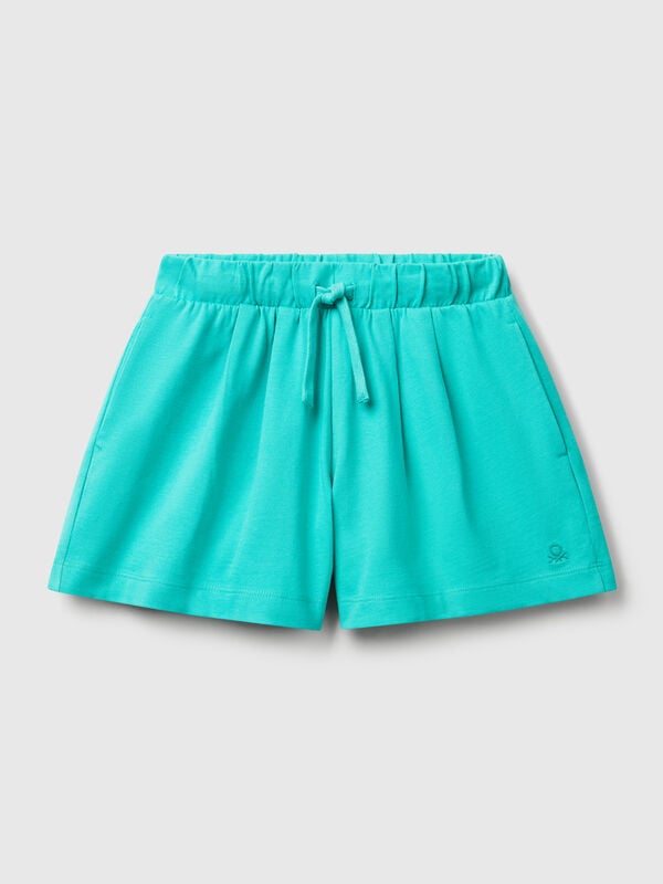Pantalón corto de puro algodón de tacto cálido. Cintura con cordón, bolsillos insertados en los laterales y logo bordado en el bajo izquierdo. Perfecto para outfits cotidianos. Niña
