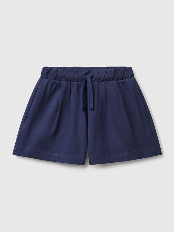 Pantalón corto de puro algodón de tacto cálido. Cintura con cordón, bolsillos insertados en los laterales y logo bordado en el bajo izquierdo. Perfecto para outfits cotidianos. Niña